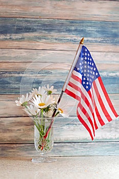 American flag and vase of daisies