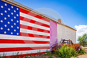 American flag, wall of a house, old fashioned truck on Route 66, is attracting visitors from all of the world Arizona