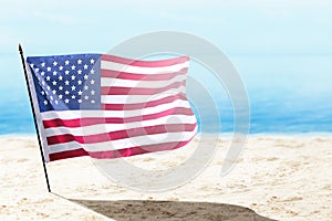 American flag waving in the air on the beach