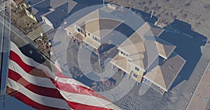 American Flag Waving With Drone Aerial View of New Home Construction Site Background