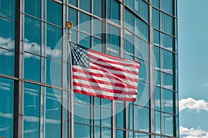 American Flag Waving in Front of Modern Glass Skyscraper Building with