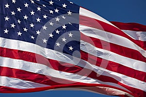 American Flag Waving In Wind Against a Deep Blue Sky