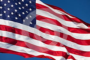 American Flag Waving In Wind Against a Deep Blue Sky