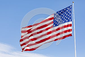 American flag waving in the wind on blue sky