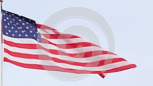 American flag waving in wind, USA. National symbol waves in breeze on flagpole.