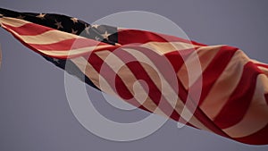American flag waving in wind, USA. National symbol waves in breeze on flagpole.