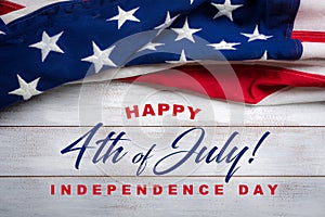 American flag on a white worn wooden background with July 4th Greeting