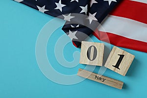 American flag and wood calendar with 1 may on blue background