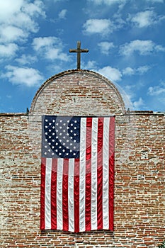 American Flag and Wooden Cross on a Brick Building