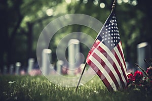 American flags and flowers by gravestones in a national cemetery. Memorial Day