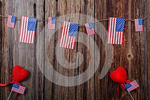 American flags on a wooden background with a heart and roses