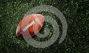American football ball on grass background