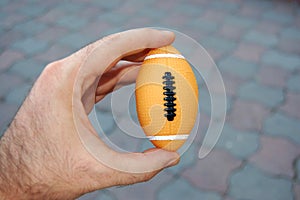 American football ball in hand