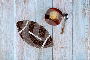 American football ball made from coffee beans with cup of fresh coffee
