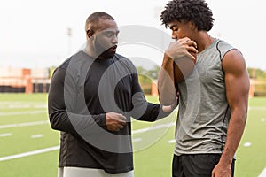 American Football coach training a young athlete.