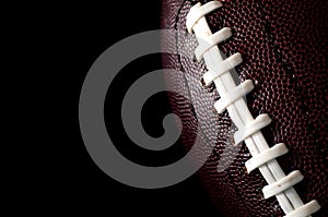 American football  and gameday poster concept with close up on the texture of a ball with dramatic moody light with high contrast