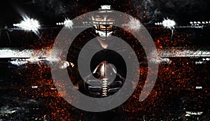 American football player, athlete in helmet with ball on black background. Sport wallpaper with copyspace.