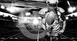 American football player, athlete in helmet with ball on stadium. Black and white photo. Sport wallpaper with copyspace.