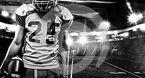 American football player, athlete in helmet with ball on stadium. Black and white photo. Sport wallpaper with copyspace.