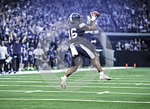 American Football Player catching a pass during a game.