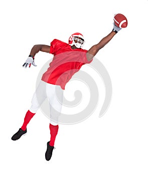 American football player catching rugby ball