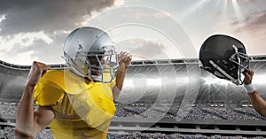 american football player cheering and holding up helmet