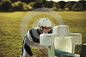 American football player doing tackling drills on a field