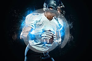 American football player in helmet with ball in hands. Fire background. Team sports. Sport wallpaper.