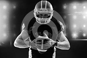 American football player in helmet holding rugby ball