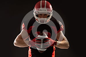 American football player in helmet holding rugby ball