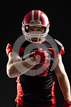 American football player in helmet holding rugby ball