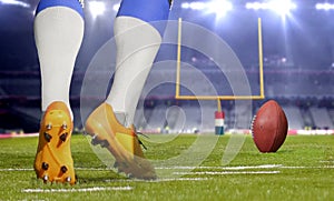 American football player kicking ball in close up