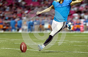 American football player kicking ball in the stadium