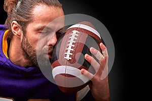 American football player kisses the ball