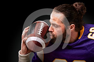 American football player kisses the ball