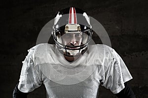 American football player looking at camera on concrete background