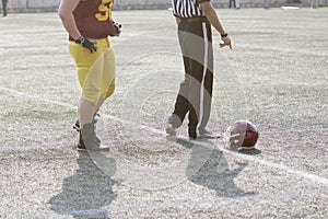 American football player, referee and helmet on the field
