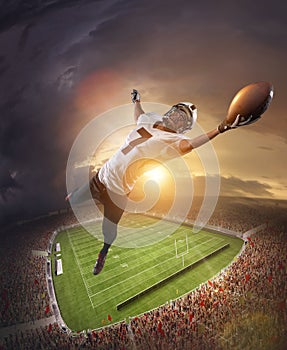 American football players catching ball in flight overt stadium with flashlights at evening time. Concept of sport