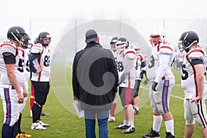 American football players discussing strategy with coach