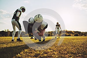 American football players doing tackling drills on a sports fiel