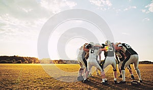 American football players in a huddle during practice