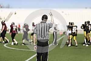 American football referee with hand up