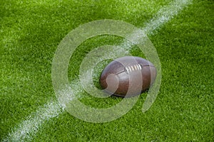 American football, rugby ball on green grass field background