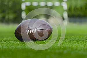 American football, rugby ball on green grass field background