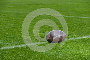 American football, rugby ball on green grass field background