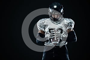 American football sportsman player in helmet on black background. Sport and motivation. Team sports.