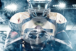 American football sportsman player on stadium with lights on background