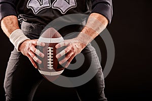 American football sportsman player on stadium with lights on black background.
