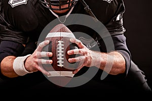 American football sportsman player on stadium with lights on black background.