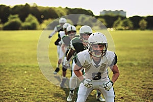 American football team doing drills on a sports field